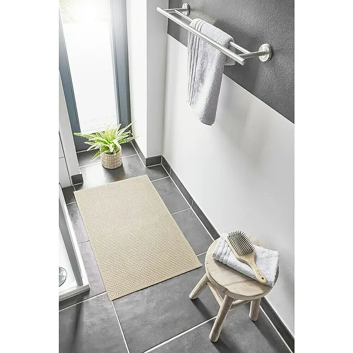 Badteppich Zottel - 50 x 80 cm, Creme, 100% Polyester - Helle beige, strukturierte Badematte auf dunklem Fliesenboden, die Komfort und Halt bietet.