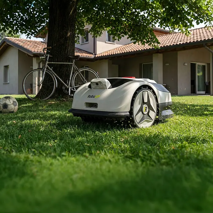 RoboUp Mähroboter Raccoon 2 SE - 600 m², Schnittbreite: 20 cm, Kamera-gestützte Navigation - Ein grau-weißer Rasenroboter mit großen Rädern, der aktiv Gras mäht.