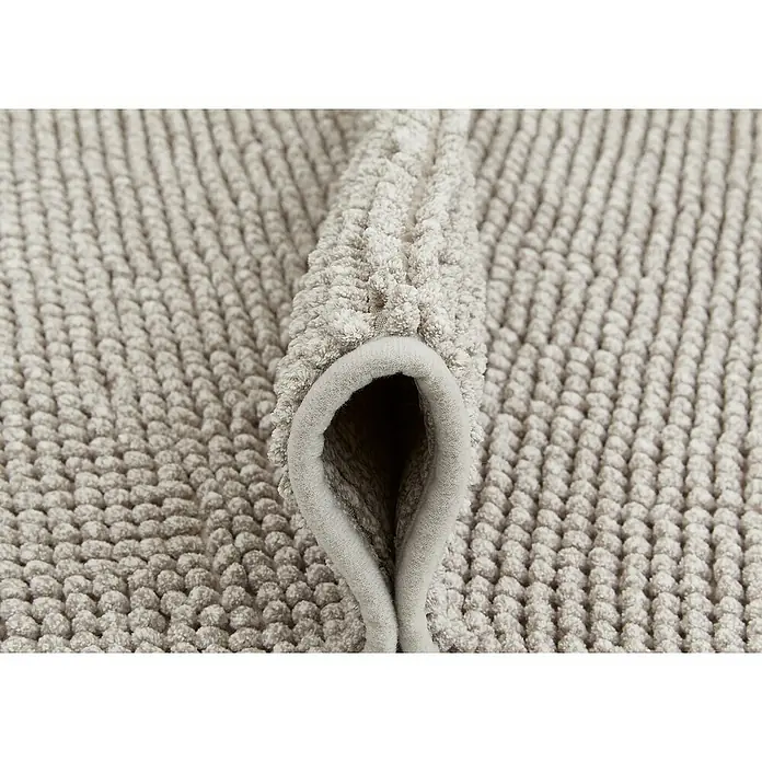Badteppich Zottel - 60 x 100 cm, Grau, 100% Polyester - Hellgraue, plüschige, getuftete Matte, gefaltet, um ihre weiche Textur und Dicke zu zeigen.
