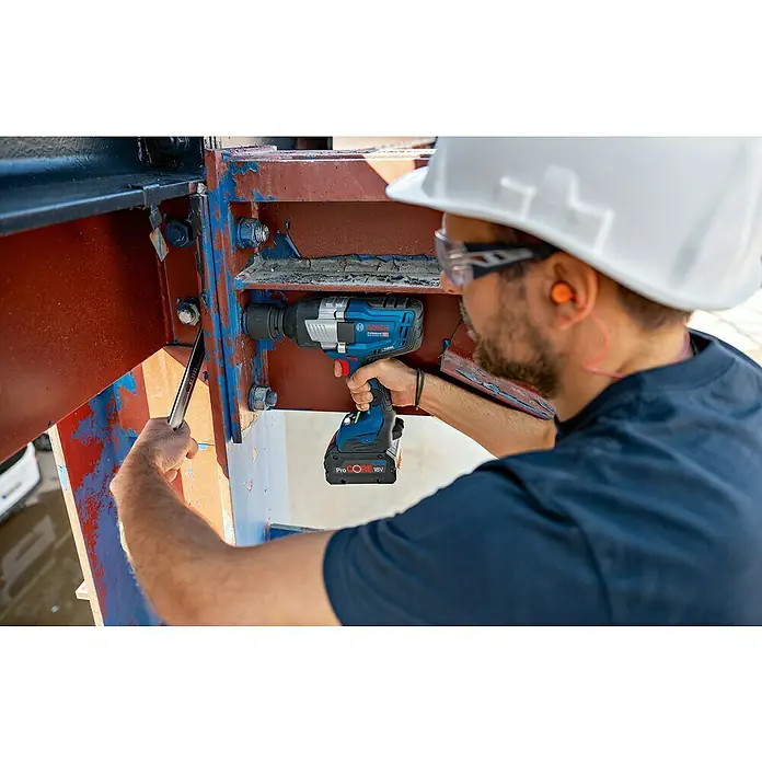 Bosch Professional AMPShare 18V Akku-Drehschlagschrauber GDS 18V-1600 HC - 18 V, Ohne Akku, 1.600 Nm, Ohne Akku, ohne Koffer - Mann in Schutzkleidung benutzt einen blauen und schwarzen Bosch Professional 18V Schlagschrauber an großen Metallkonstruktionsschrauben.