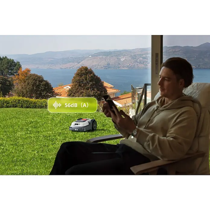 RoboUp Mähroboter T1200 - 1.500 m², Schnittbreite: 20 cm, Kamera-gestützte Navigation, RTK - Grauer und schwarzer Mähroboter mäht leise Gras im Garten (56dB), während ein Mann entspannt.