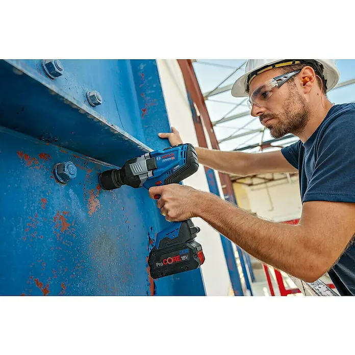 Bosch Professional AMPShare 18V Akku-Drehschlagschrauber GDS 18V-1600 HC - 18 V, Ohne Akku, 1.600 Nm, Ohne Akku, ohne Koffer - Ein Arbeiter benutzt einen blauen und schwarzen Bosch Professional Schlagschrauber, um eine Schraube an einer großen blauen Metallstruktur zu befestigen.