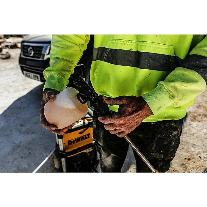 DeWalt XR 18V Akku-Hochdruckreiniger DCMPW1600N-XJ - 18 V, Ohne Akku - Person schließt transparente Flasche mit pinker Reinigungslösung an schwarze Spritzpistole an.