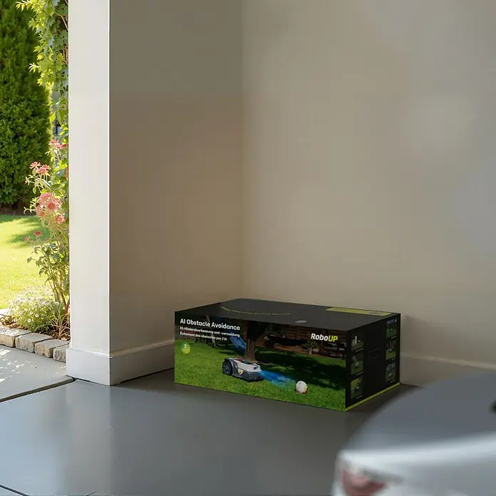 RoboUp Mähroboter T600 - 800 m², Schnittbreite: 20 cm, Kamera-gestützte Navigation, RTK - RoboUP Rasenmäher-Roboter-Box, mit KI-Hindernisvermeidung, in Garageneinfahrt.