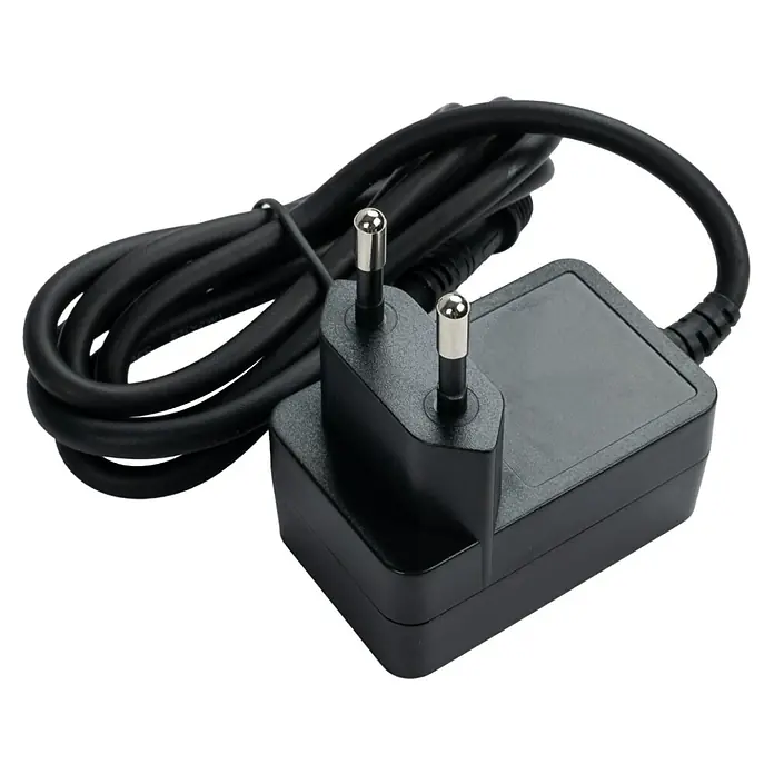 RoboUp Zusatzmodul für Mähroboter - RoboUP TM01 Serie - Schwarzes Netzteil mit zweipoligem Stecker und gewickeltem schwarzem Kabel.