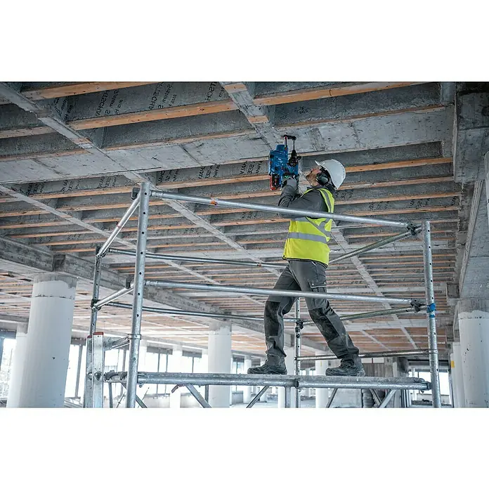 Bosch Professional AMPShare 18V Akku-Kombihammer Pro Heavy Duty GBH 18V-28 C - 18 V, Ohne Akku, 3,3 J, Mit L-BOXX - Arbeiter auf Gerüst bohrt mit blau-schwarzem Bohrhammer in Betondecke.