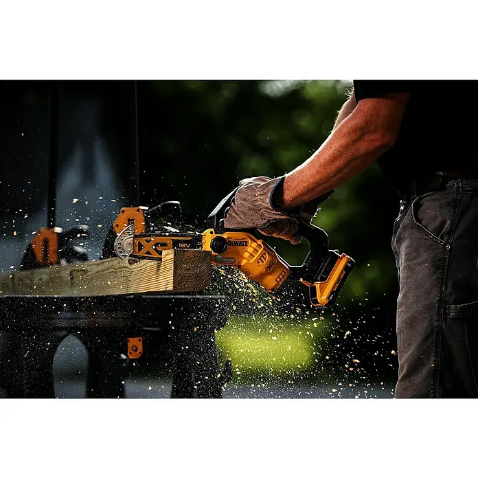 DeWalt XR 18V Akku-Kettensäge DCMPS520N-XJ - 18 V, Ohne Akku, Schwertlänge: 20 cm - Behandschuhte Hände bedienen eine gelb-schwarze DeWalt 18V XR Akku-Minikettensäge, die Holz mit fliegenden Spänen schneidet.
