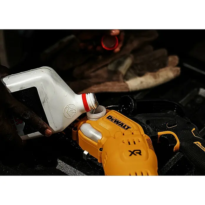 DeWalt XR 18V Akku-Kettensäge DCMPS520N-XJ - 18 V, Ohne Akku, Schwertlänge: 20 cm - Eine Person füllt Flüssigkeit aus einer weißen Flasche in ein gelb-schwarzes DeWalt XR Werkzeug.