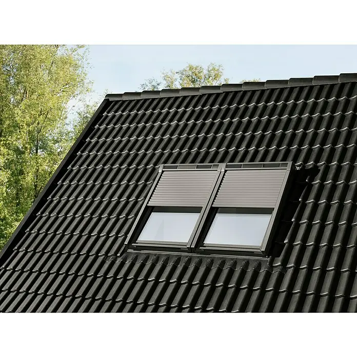 Velux Dachfenster-Rollladen Solar SSL CK06 0000K - Passend für Fenstergröße: CK06, C06, Passend für Fenstertyp: GGL, GGU, GPL, GPU, GHL, GHU, GZL, GLL, GLU, VU und VKU - Zwei graue Dachfenster mit Rollläden, eingebaut in ein dunkles Ziegeldach.