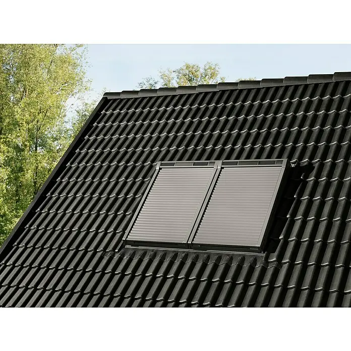 Velux Dachfenster-Rollladen Solar SSL CK06 0000K - Passend für Fenstergröße: CK06, C06, Passend für Fenstertyp: GGL, GGU, GPL, GPU, GHL, GHU, GZL, GLL, GLU, VU und VKU - Zwei hellgraue Rollläden an Dachfenstern, auf einem dunklen Ziegeldach montiert.
