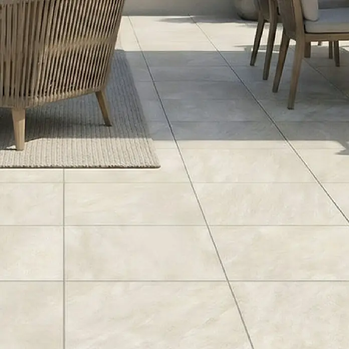 Granulati Zandobbio Terrassenfliese Colosseo - 60 x 60 x 2 cm, Barge, Matt - Helle beigefarbene Outdoor-Bodenfliesen mit subtiler Steinoptik-Textur, auf einer modernen Terrasse verlegt.