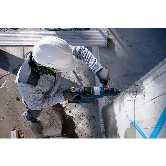 Bosch Professional AMPShare 18V Akku-Bohrhammer GBH 18V-34 CF - 18 V, 2 Akkus, 5,5 Ah, 5,8 J - Eine Person bohrt mit einem blau-schwarzen Bosch Bohrhammer in Beton.