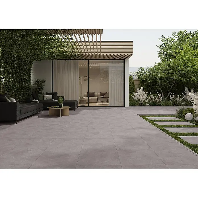 Cersanit Terrassenfliese Metropolis - 59,3 x 119,3 x 2 cm, Grey, Matt - Große graue Terrassenplatten und passende Trittsteine im Gras, die einen modernen Außenbereich bilden.