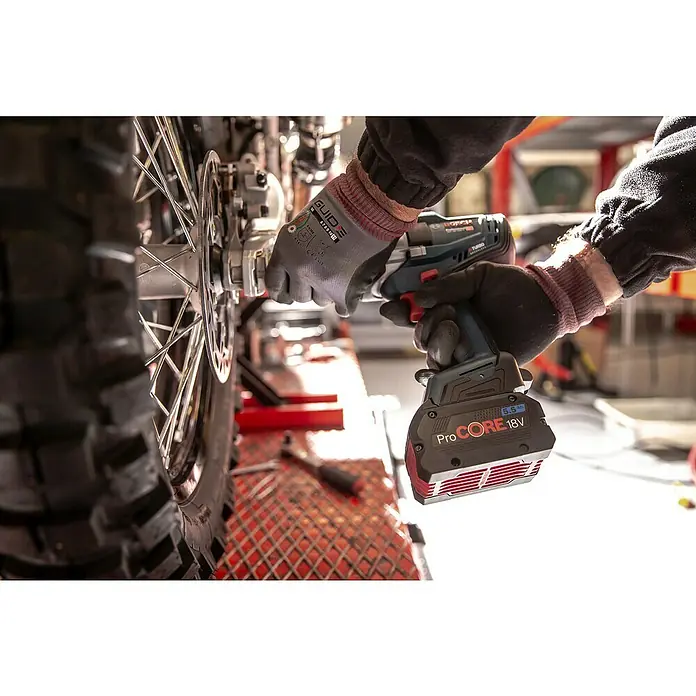 Bosch Professional AMPShare 18V Akku-Drehschlagschrauber - 18 V, 2 Akkus, 5,5 Ah, 1.000 Nm - Person mit Handschuhen verwendet ein blau-schwarzes Bosch ProCORE 18V Elektrowerkzeug am Motorradrad.