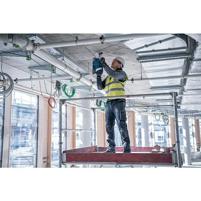 Bosch Professional AMPShare 18V Maschinen-Set 2-Tool-Kit GSR + GBH - 18 V, 2 Akkus, 4 Ah, 6 -tlg. - Arbeiter nutzt blaues Akku-Befestigungsgerät an Betondecke.