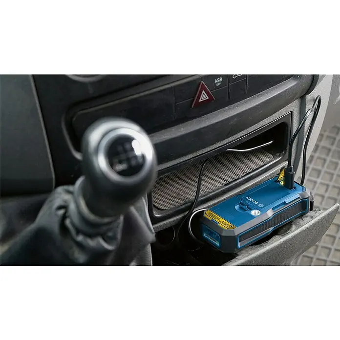 Bosch Professional USB-Akku-Adapter PRO BA 3.7V 1.0Ah A - Akkuspannung: 3,7 V, Höchste Leistung Einzelakku: 5 Wh - Blaues Bosch-Gerät, wahrscheinlich ein Laser-Messgerät, wird über USB im Armaturenbrett eines Autos geladen.