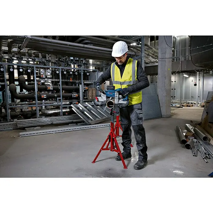 Bosch Professional AMPShare 18V Akku-Bandsäge GCB 18V-127 - 18 V, Ohne Akku - Ein Arbeiter schneidet mit einer blauen Bosch Akku-Bandsäge auf einem roten Stativ ein Metallrohr.