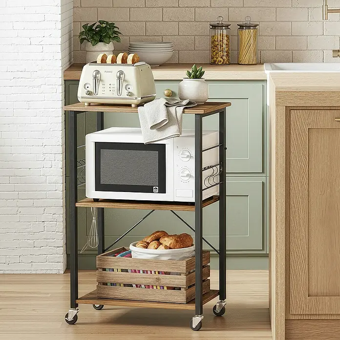 Servierwagen - L x B x H: 40 x 60 x 89 cm, Schwarz/Braun - Dreistöckiger Küchenwagen aus Holz und schwarzem Metall auf Rollen, mit Mikrowelle und Toaster in einer Küche.