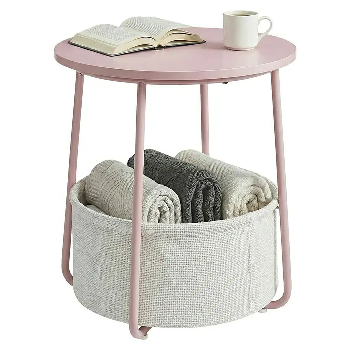 Beistelltisch - Ø x H: 45 x 51 cm, Pink - Hellrosafarbener runder Beistelltisch mit integriertem naturweißem Stoffkorb. Enthält gerollte Decken; ein Buch und eine Tasse sind oben.
