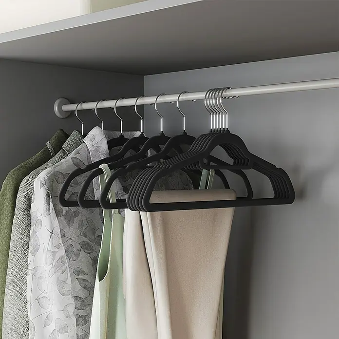Kleiderbügel Samt - Schwarz, 20 Stk., Samtoberfläche - Schwarze Samtbügel halten verschiedene Kleidungsstücke an einer silbernen Kleiderstange im Schrank.