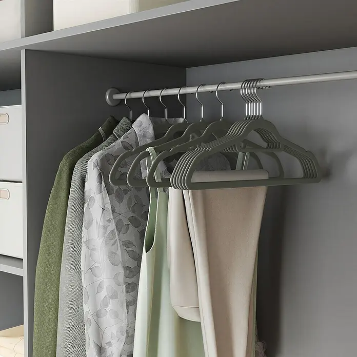 Kleiderbügel Samt - Grau, 20 Stk., Samtoberfläche - Beflockte olivgrüne Kleiderbügel organisieren verschiedene Kleidungsstücke in einem grauen Kleiderschrank.