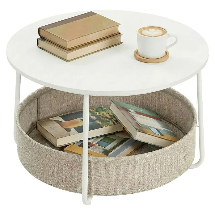 Couchtisch - Ø x H: 75 x 45 cm, Weiß - Weißer runder Couchtisch mit integriertem hellgrauen Stoff-Aufbewahrungskorb, gefüllt mit Büchern und einer Kaffeetasse.
