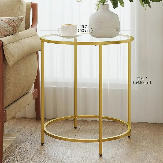 Beistelltisch - Ø x H: 50 x 55 cm, Gold - Eleganter runder Beistelltisch in Gold mit klarer Glasplatte, neben einem Sessel im Wohnzimmer gezeigt, Maße angegeben.