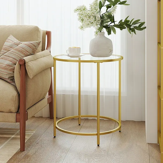 Beistelltisch - Ø x H: 50 x 55 cm, Gold - Runder Beistelltisch mit Glasplatte und goldenem Metallgestell, neben einem Sofa stehend, mit Tasse und Vase.