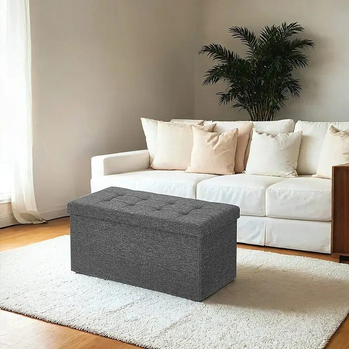 Hocker mit Stauraum - L x B x H: 38 x 76 x 38 cm, Grau - Grauer getufteter Aufbewahrungshocker im Wohnzimmer auf einem weißen Teppich vor einem Sofa.
