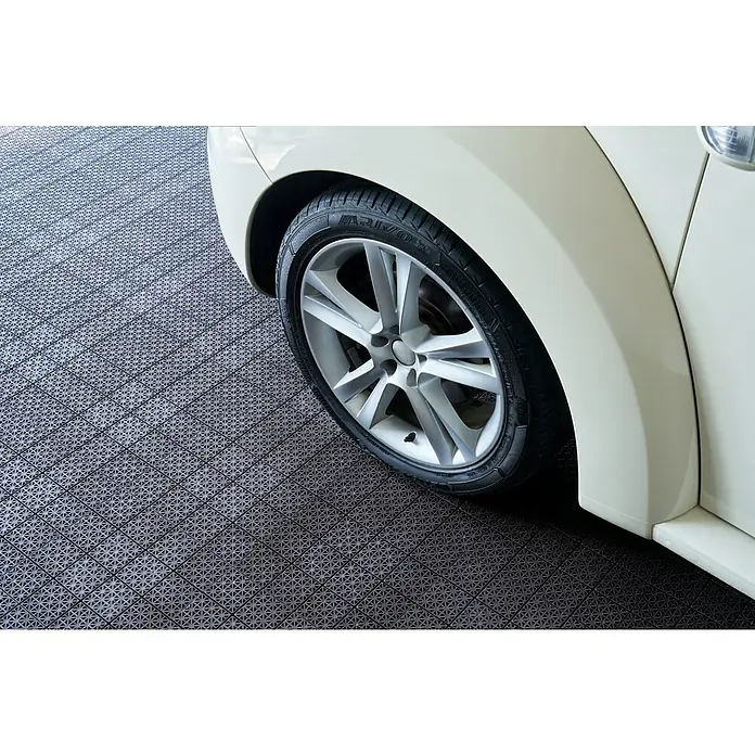Loseta con sistema click - Polipropileno reciclado, 30 x 30 x 1,2 cm, Marrón, 1 ud. - Baldosas modulares gris oscuro para garaje con superficie estampada, bajo una rueda de coche.