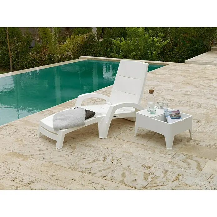 Mesa auxiliar de jardín Alaska - L x An x Al: 58 x 48 x 30 cm, Polipropileno, Blanco - Tumbona blanca de jardín y mesa auxiliar junto a la piscina. La tumbona tiene una toalla y la mesa tiene bebidas y una revista.
