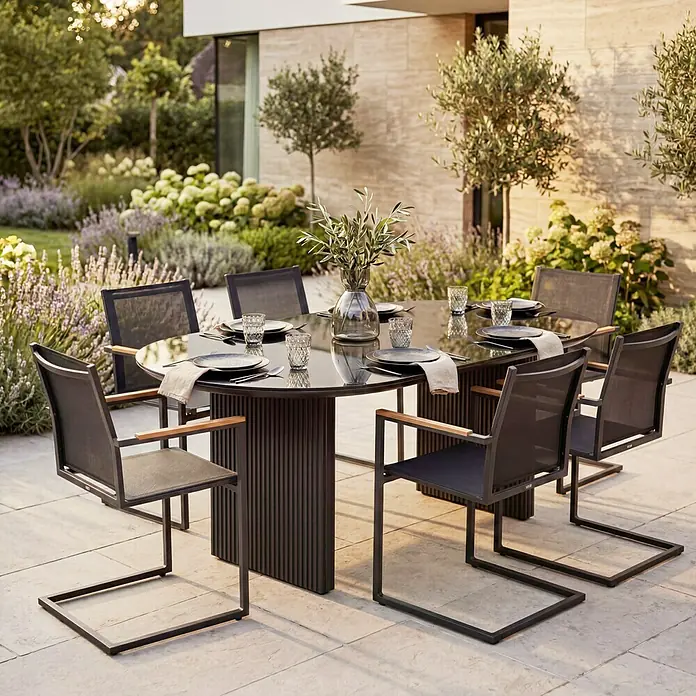 SENSUM Gartentisch Skuru - L x B x H: 220 x 100 x 74 cm, Aluminium, Glas, Schwarz - Modernes dunkles Outdoor-Essgruppe mit rundem Tisch und Stühlen mit Holzarmlehnen auf einer Terrasse.