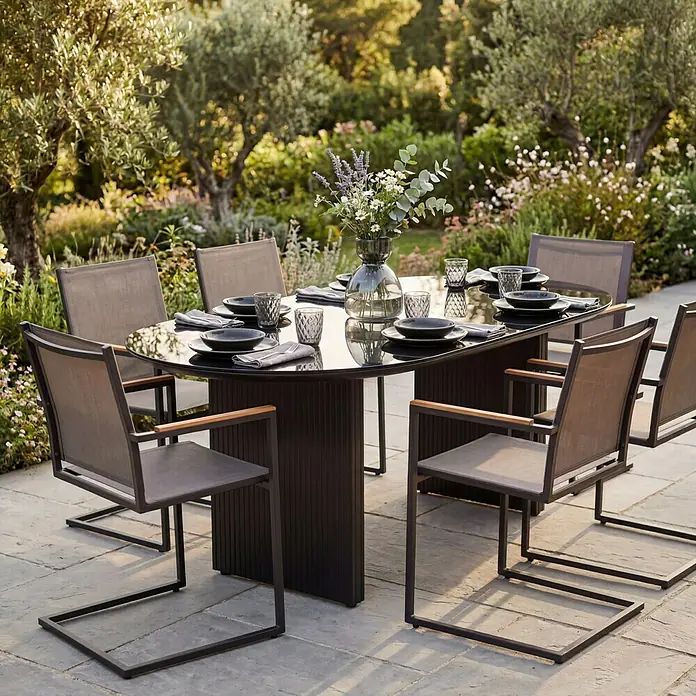 SENSUM Gartenstuhl Skuru - Edelstahl, Schwarz, B x T x H: 58 x 55 x 86 cm - Dunkle Outdoor-Essgruppe mit sechs Stühlen und einem Spiegeltisch, auf einer Terrasse, mit Geschirr und Blumen gedeckt.