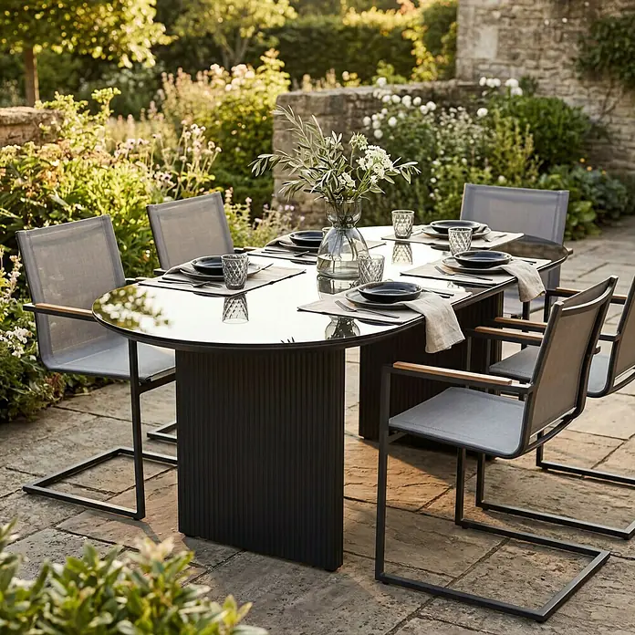 SENSUM Gartentisch Skuru - L x B x H: 220 x 100 x 74 cm, Aluminium, Glas, Schwarz - Dunkelgraue Outdoor-Essgruppe mit Glastisch und passenden Netzstühlen, gedeckt im sonnigen Garten.