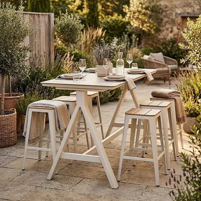 Garten-Stehtisch - L x B x H: 160 x 70 x 102 cm, Aluminium, Verbundwerkstoff, Rechteckig, Natural Warm Grey - Eine Outdoor-Essgruppe mit hellem Tisch und vier Hockern mit Holzsitzen, auf einer Terrasse für eine Mahlzeit gedeckt.