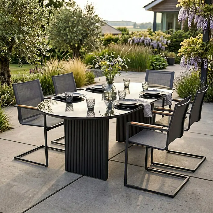 SENSUM Gartentisch Skuru - L x B x H: 220 x 100 x 74 cm, Aluminium, Glas, Schwarz - Eine Outdoor-Essgruppe mit einem dunkelgrauen, geriffelten Tisch mit Glasplatte und sechs Stühlen mit dunkelgrauem Netzgewebe und Holzarmlehnen auf einer Terrasse.