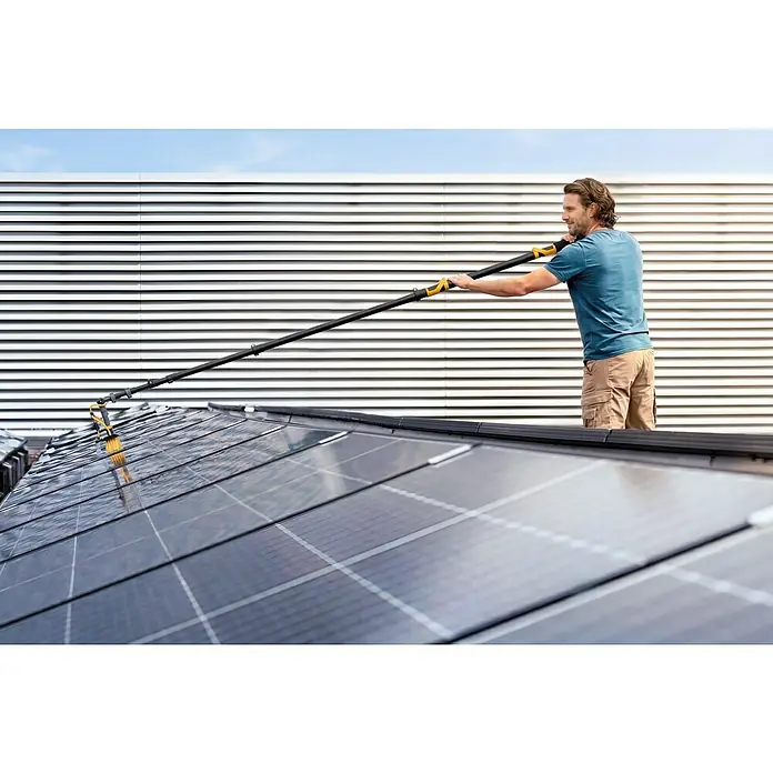 Neptun PV-  & Fassaden Reinigungsset mit verschiedenen Aufsätzen - Teleskopstiel, 120 cm - 490 cm - Mann reinigt Solarpanels mit einer langen schwarz-gelben Bürste.