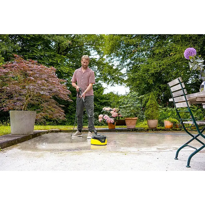 Kärcher Hochdruckreiniger K 7 Comfort Premium Home - 180 bar, 3.000 W, Fördermenge: 600 l/h, Inkl. Home-Kit - Gelb-schwarzer Kärcher Flächenreiniger wird zum Reinigen einer Betonterrasse verwendet.
