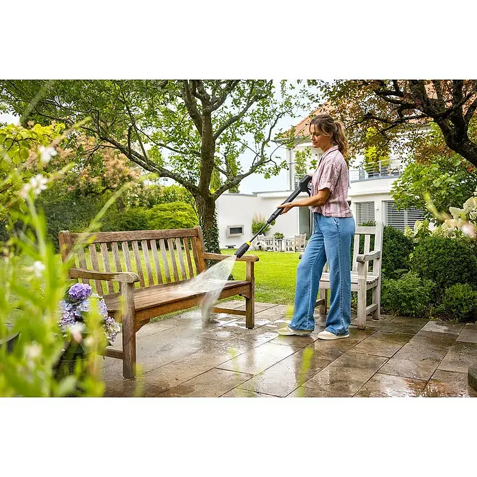 Kärcher Hochdruckreiniger K 7 Comfort Premium - 180 bar, 3.000 W, Fördermenge: 600 l/h, Ohne Home-Kit - Eine Frau reinigt mit einem schwarz-gelben Hochdruckreiniger eine hölzerne Gartenbank auf einer Terrasse.