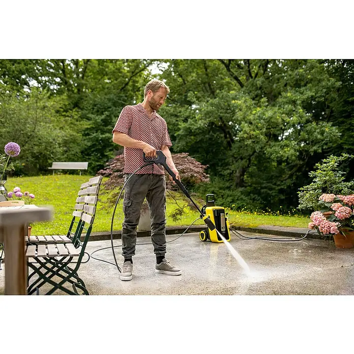 Kärcher Hochdruckreiniger K 7 Comfort Premium - 180 bar, 3.000 W, Fördermenge: 600 l/h, Ohne Home-Kit - Ein Mann reinigt eine Betonterrasse mit einem gelben und schwarzen Hochdruckreiniger.
