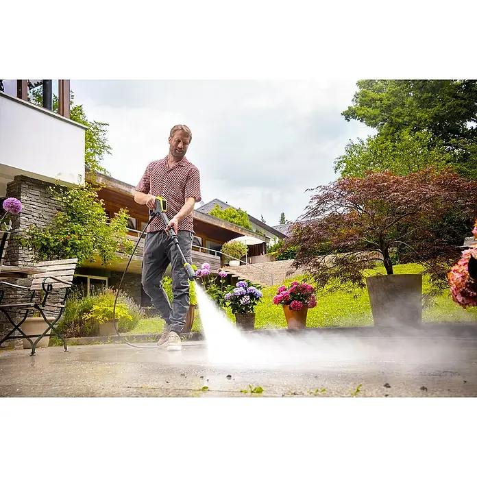 Kärcher Hochdruckreiniger K 7 Comfort Premium Connect - 3.000 W, Max. Druck: 180 bar, Fördermenge: 600 l/h, Ohne Home-Kit - Ein Mann reinigt eine Terrasse mit einem gelb-schwarzen Hochdruckreiniger, der Wasser versprüht.