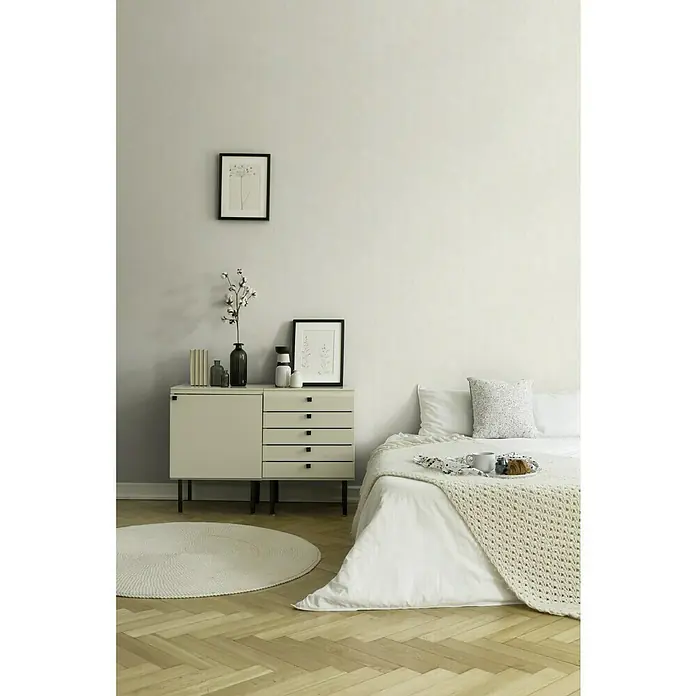 A.S. Création New Walls Vliestapete - Weiß, Uni, 10,05 x 0,53 m - Elegantes Schlafzimmerinterieur mit einem stilvollen Sideboard, das mit dekorativen Vasen, Büchern und gerahmten Bildern geschmückt ist. Das Bett mit weißer Bettwäsche lädt zum Entspannen ein.