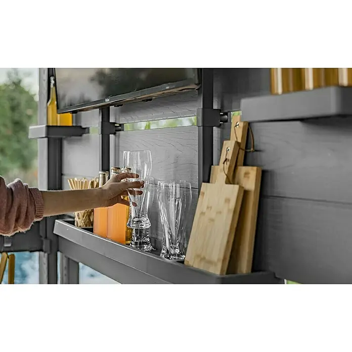 Keter Pérgola para barbacoa Bar Gazebo - An x Pr: 230 x 200 cm, Antracita, Plástico - Sistema de bar exterior modular gris, con estantes para vasos y tablas de cortar; una mano coge un vaso, listo para el entretenimiento.