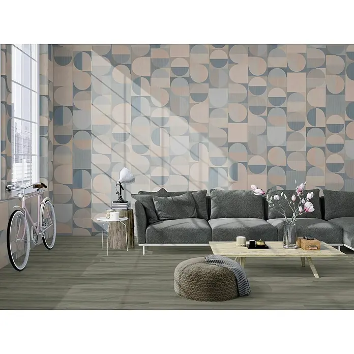 Granorte Designboden Kenkotrend - Ashland, 1.164 x 300 x 8,5 mm - Geometrische Tapete mit blauen, grauen und rosa Kreisen/Halbkreisen, die eine Wohnzimmerwand hinter einem grauen Sofa schmückt.