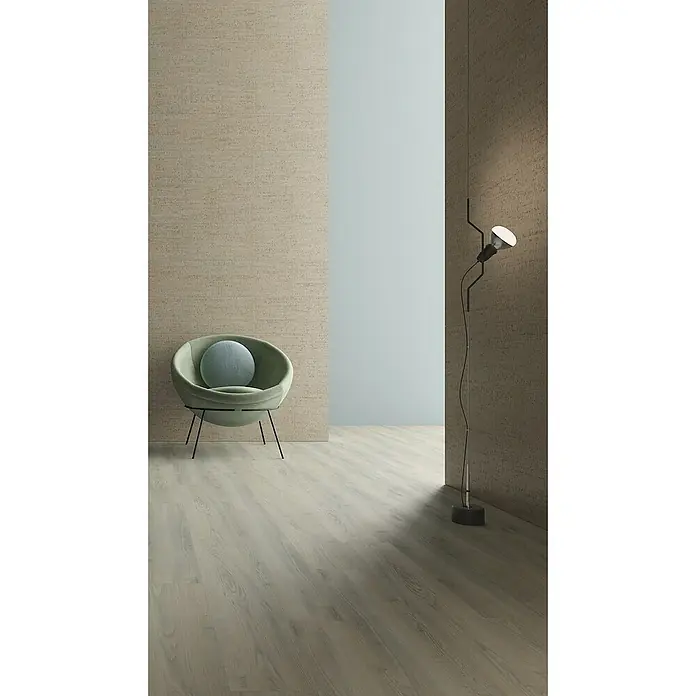 Granorte Designboden Kenkotrend - Ashland, 1.164 x 300 x 8,5 mm - Ein moderner Wohnraum mit hellem Holzboden, strukturierten beigefarbenen Wänden, einem grünen Sessel und einer schwarzen Stehlampe.