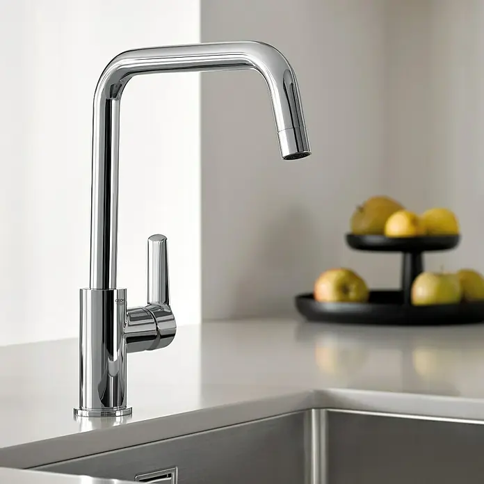 Grohe Start Spültischarmatur - Chrom, Glänzend, U-Auslauf - Verchromte Küchenarmatur auf heller Arbeitsplatte mit Edelstahlspüle, Früchte im Hintergrund.