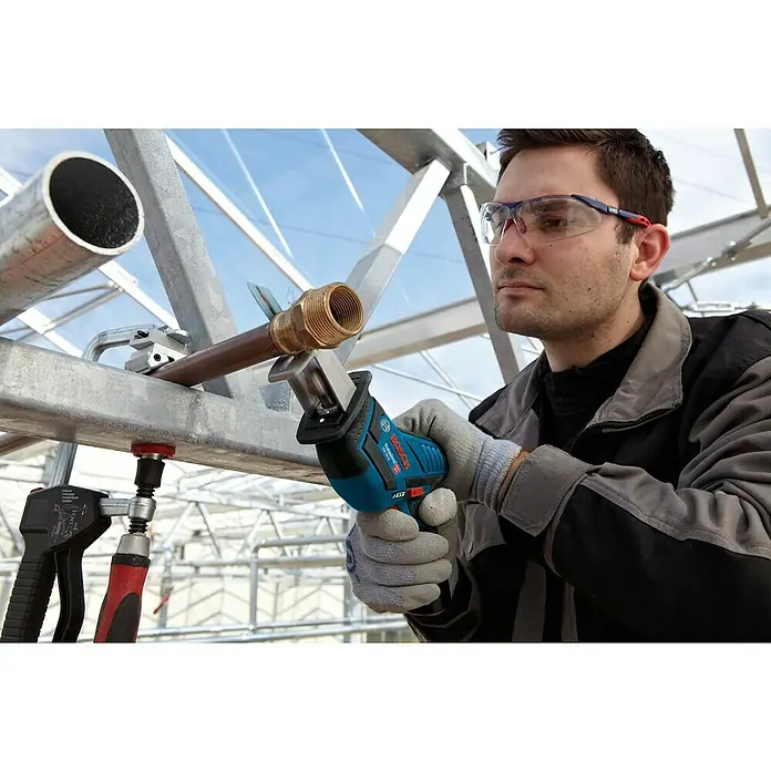 Bosch Professional Maschinen-Set 5-Tool-Kit GSR+GOP+GDR+GSA+GLI - 12 V, 3 Akkus, 2 Ah, 10 -tlg. - Mann schneidet mit blauer Bosch Säbelsäge ein Kupferrohr.