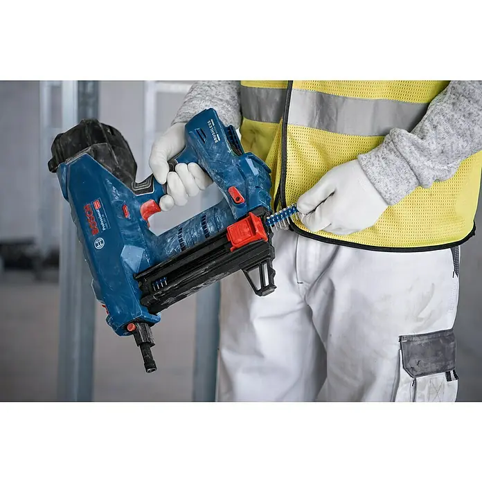 Bosch Professional Streifennägel NB-19 PRO - Länge Nagel: 19 mm, Verzinkt, 1.000 Stk. - Blauer Bosch Professional Nagler wird von einer Person mit Handschuhen mit Nagelstreifen geladen.