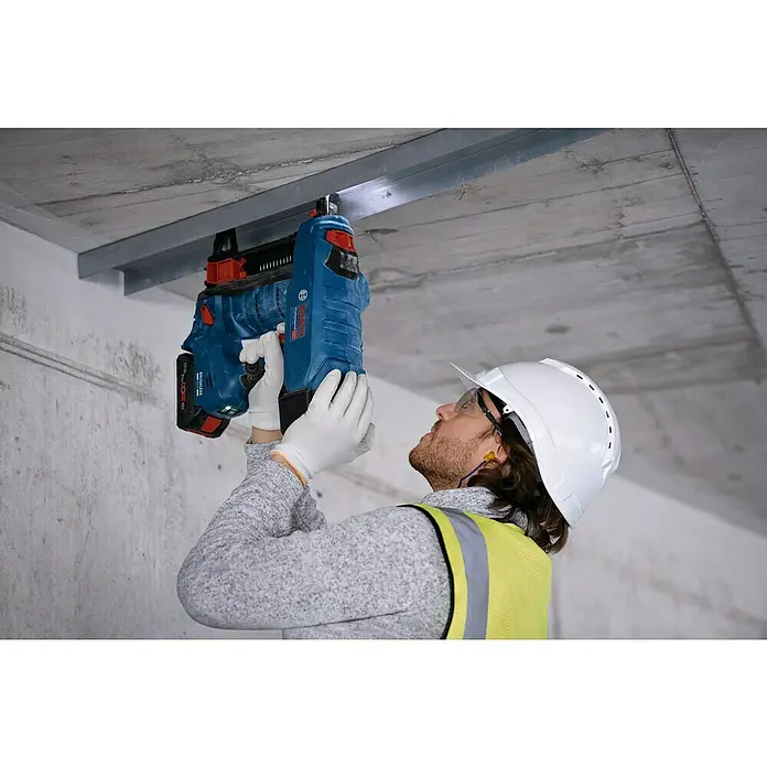 Bosch Professional Akku-Nagler GNB 18V-38PRO - 18 V, 2 Akkus, Länge Nagel: 13 mm - 38 mm - Mitarbeiter befestigt mit blauem Bosch Akku-Nagler eine Metallschiene an einer Betondecke.