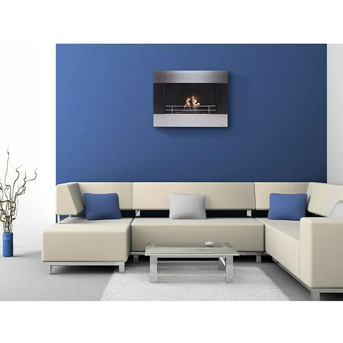 Purline Chimenea de bioetanol Ceo - 21 x 80 x 60 cm, Inox - Vista moderna de la sala de estar con una elegante chimenea de bioetanol en la pared azul, complementada con un sofá crema y una mesa de centro minimalista.